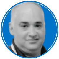 The image shows a headshot of a middle-aged man with a bald head and a friendly expression against a bright blue background.
